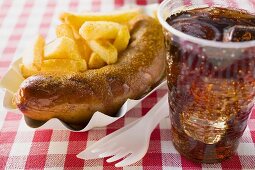 Sausage with ketchup & curry powder, chips & cola in restaurant