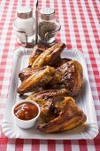 Grilled chicken wings with ketchup on paper plate