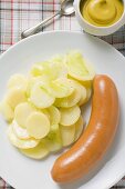 Frankfurter with potato salad, mustard in small dish