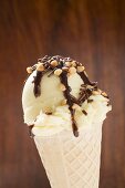 Cone of nut ice cream with chocolate sauce