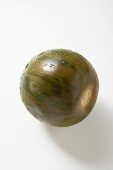 Green striped tomato with drops of water