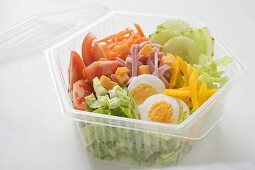 Eissalat mit Schinken, Käse, Ei und Gemüse in Plastikschale