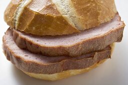 Slices of Leberkäse (a type of meatloaf) in a roll