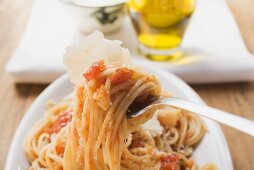 Spaghetti with tomato and Parmesan on fork