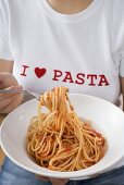 Woman eating spaghetti with tomato sauce