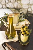 Oliven, Olivenöl, Käse und Cracker auf Tisch im Freien