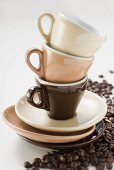 Three espresso cups and saucers, stacked, coffee beans