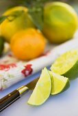 Lime wedges and squeezed lime in front of citrus fruit