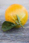 Oranges with leaves on wooden background