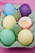 Coloured boiled eggs in egg box