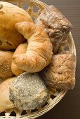 Bread rolls and croissants in bread basket (detail)