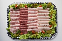 Cold cut platter garnished with gherkins (overhead view)