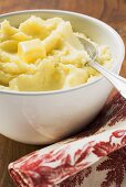 Kartoffelpüree mit Butter in weisser Schüssel mit Löffel
