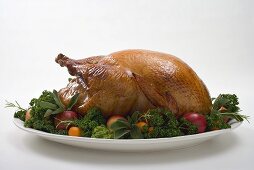 Roast turkey garnished with fruit and herbs