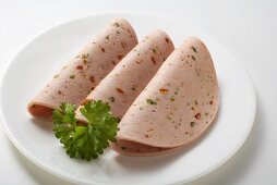 Three slices of Pikantwurst (sausage with red & green pepper)