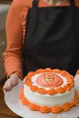 Frau hält Teller mit Torte für Halloween