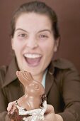 Laughing woman holding chocolate Easter Bunny with a bite taken