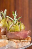 Figs wrapped in raw ham on toast