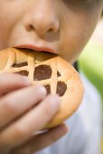 Child biting into chocolate tartlet
