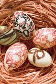 Decorated chocolate eggs in Easter nest (overhead view)