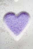 Purple sugar in heart-shaped biscuit mould