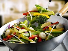 Mixed vegetables in wok and on spatula