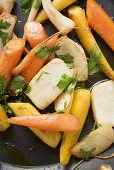 Fried root vegetables with parsley in frying pan