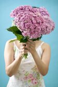 Woman holding bunch of hydrangeas