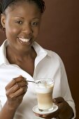Frau hält Glas Latte Macchiato