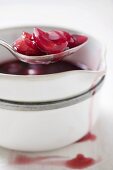 Cherry compote in pan and on spoon