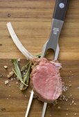 Lamb chop with rosemary and salt on meat fork
