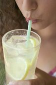 Young woman drinking lemonade through a straw