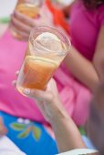 Women in summer clothes holding glasses of iced tea