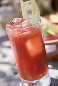 Tomato drink with celery and ice cubes