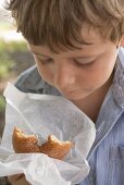 Small boy holding doughnut in paper