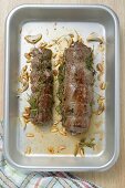 Beef roulades with herbs and pine nuts in roasting tin