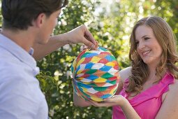 Couple decorating garden with Chinese lanterns