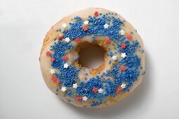 Doughnut mit Zuckerstreuseln und -sternen (rot, blau, weiss)