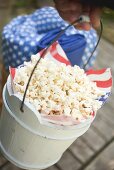 Hand hält Popcorn im Holzeimer (4th of July, USA)
