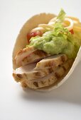 Folded tortilla filled with chicken, guacamole and cheese