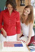 Frau schneidet Torte an am 4th of July (USA)