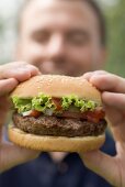 Man holding large hamburger
