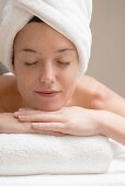 Woman lying down, resting on white towel