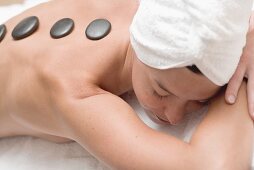 Woman having LaStone Therapy (healing therapy using stones)