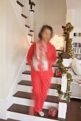 Woman carrying boxes of Christmas decorations into living room