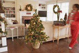 Woman carrying boxes of Christmas decorations into living room