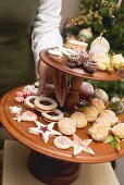 Hand reaching for Christmas biscuit on tiered stand