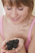 Frau hält Brombeeren