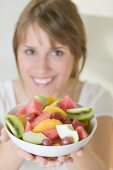 Woman holding dish of fruit salad