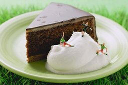 Piece of Sacher torte with cream and football figures